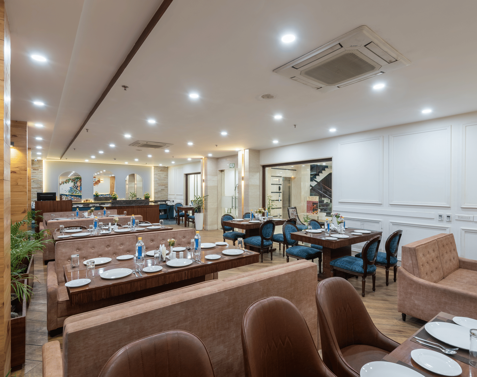 Seating area of a restaurant featuring multiple sofas and chairs with cutlery neatly arranged on the table at DLS The Classio